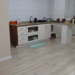 Uma cozinha com armários brancos e bancada clara é visível na propriedade.