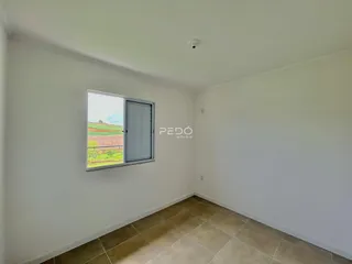 Ambiente interno com parede branca e piso de cerâmica.