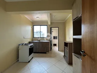 Vista interna de uma cozinha com piso de cerâmica e armários em Lajeado, Brasil.