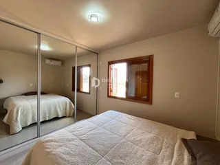 Quarto com cama e janela de madeira.