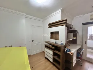 Interior de um cômodo com paredes brancas e piso de madeira clara.