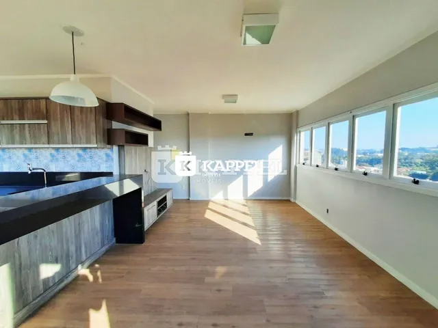 Vista interna de uma cozinha moderna com armários de madeira e piso de madeira.