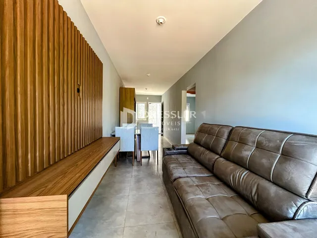 Hall de entrada com sofá e painel de madeira na residência.