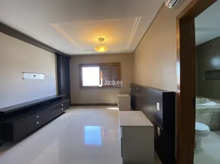 Hall de entrada com piso claro e armário longo.