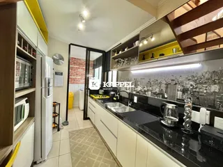 Uma cozinha moderna com armários brancos e bancadas escuras é visível na propriedade.