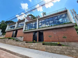 Fachada de um imóvel residencial em tijolos vermelhos com grandes janelas.