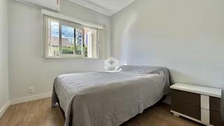 Quarto com cama e janela em ambiente claro.