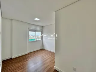 Ambiente interno com piso de madeira e paredes brancas.