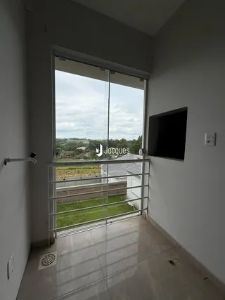 Vista de um ambiente interno com porta de vidro e vista para o exterior.