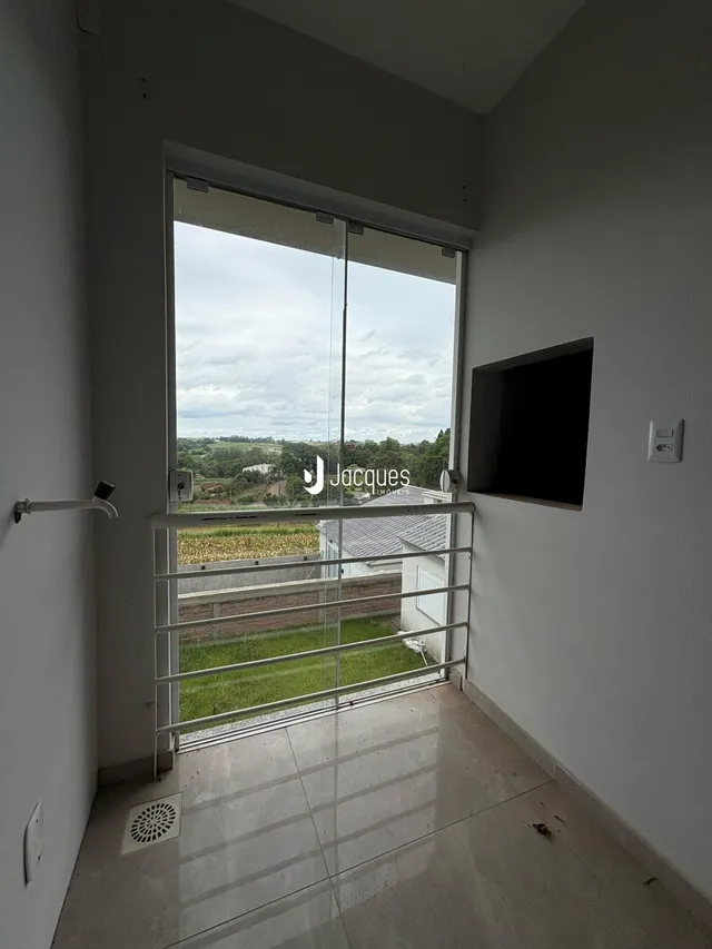 Vista de um ambiente interno com porta de vidro e vista para o exterior.