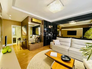 Sala de estar com piso de madeira e sofá branco.