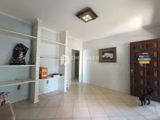 Hall de entrada com paredes brancas e piso de cerâmica clara.