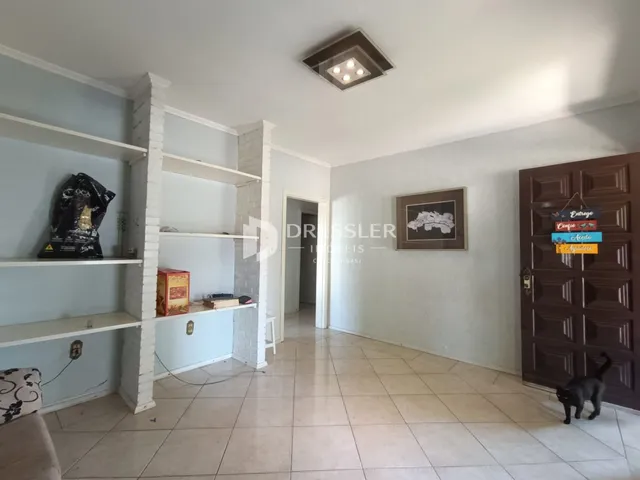 Hall de entrada com paredes brancas e piso de cerâmica clara.