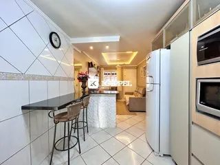 Ambiente interno com bancada e refrigerador em um imóvel.