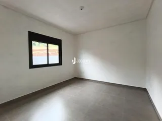 Ambiente interno de uma sala com parede branca e piso claro.