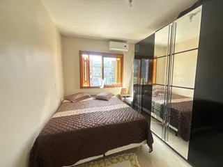 Quarto com cama e janela de madeira no interior da residência.