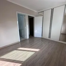 Hall de entrada com piso de madeira e paredes brancas.