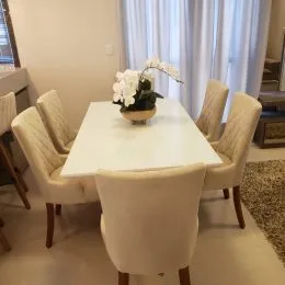 Foto de uma sala de estar com mesa e cadeiras brancas.