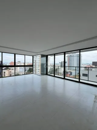 Sala ampla com grandes janelas que proporcionam uma vista panorâmica da cidade.