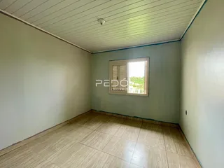 Ambiente interno de um cômodo com piso de cerâmica clara e teto de ripas.