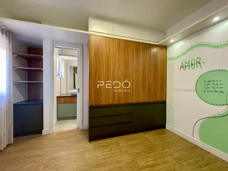 Ambiente interno de uma sala com armários de madeira e piso de madeira clara.