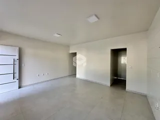 Vista de um corredor interno com paredes brancas e piso de cerâmica.