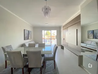 Sala de estar com sofá e cadeiras em ambiente claro.
