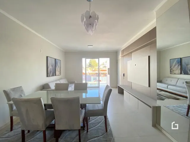 Sala de estar com sofá e cadeiras em ambiente claro.
