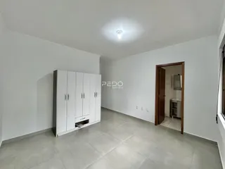 Interior de um ambiente com paredes brancas e piso cinza claro.