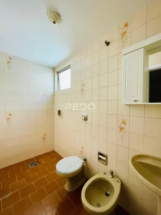 Foto de um banheiro com piso de cerâmica e paredes brancas.