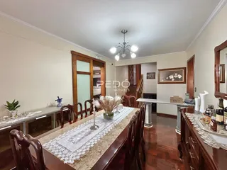 Sala de jantar com mesa de madeira e detalhes em renda.