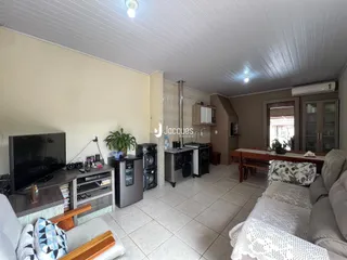 Sala de estar com cozinha integrada e área de jantar em imóvel no Lajeado.