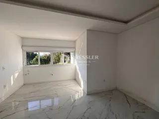 A sala possui piso de mármore claro e paredes brancas.