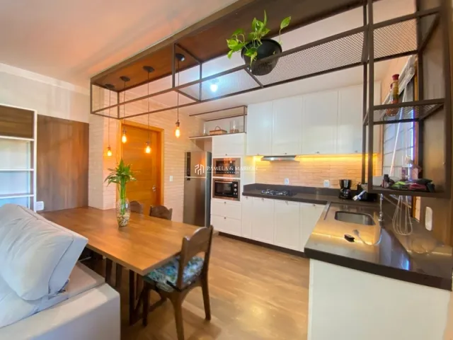 Foto de uma cozinha com armários brancos e piso de madeira.