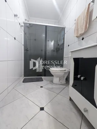 Hall de entrada com piso de cerâmica e portas de vidro.