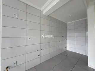 Corredor interno com paredes brancas e piso cinza.