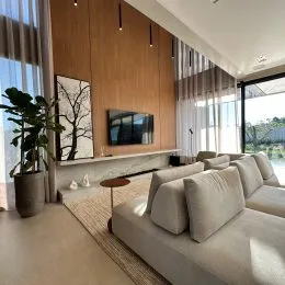 Sala de estar com sofá claro e painéis de madeira.