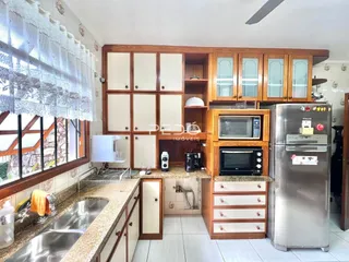Uma cozinha com armários de madeira e eletrodomésticos.