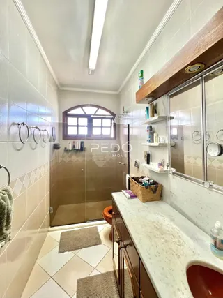 Foto de um banheiro com revestimento cerâmico nas paredes e piso claro.
