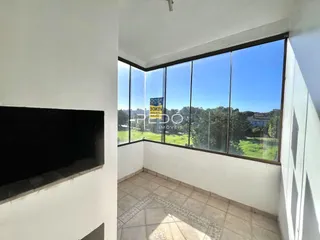 Vista de uma sala com grandes janelas que dão para a paisagem.