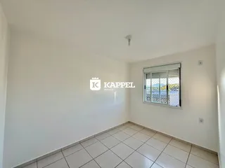 Uma sala clara com piso de cerâmica e janela.