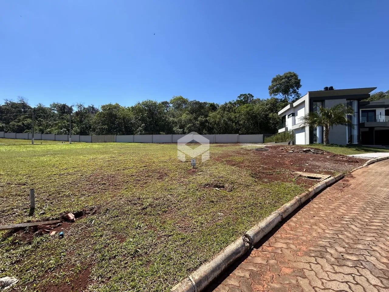 Vista externa de uma propriedade com campo aberto e cerca no fundo