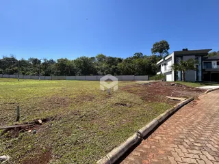 Vista externa de uma propriedade com campo aberto e cerca no fundo