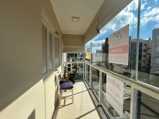 Vista de um corredor com janelas e grade de vidro em um imóvel em Lajeado.
