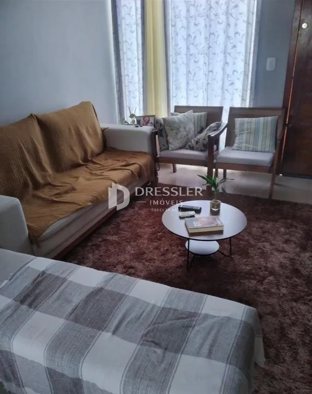 Sala de estar com sofá e cama em ambiente claro.