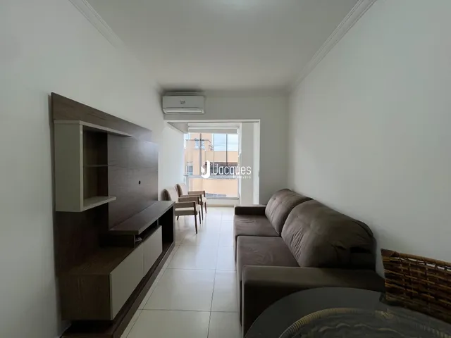 Sala de estar com móveis de madeira e piso de cerâmica.