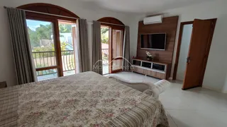 Quarto com cama grande e portas de vidro que dão acesso a uma área externa.