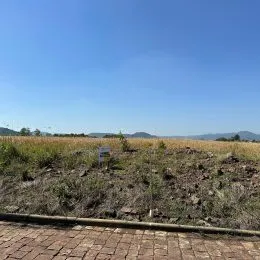 Vista de um campo aberto sob um céu azul.