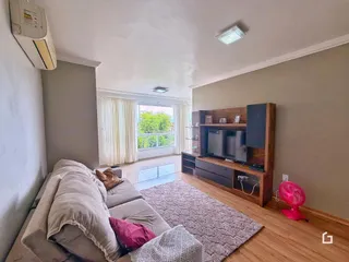 Sala de estar com sofá e janela de vista para o exterior.