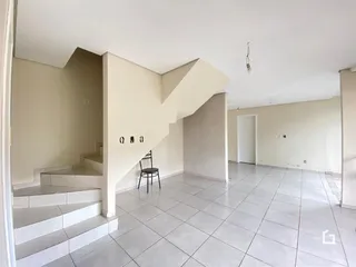 Ambiente interno de uma sala com piso de cerâmica e escadaria.